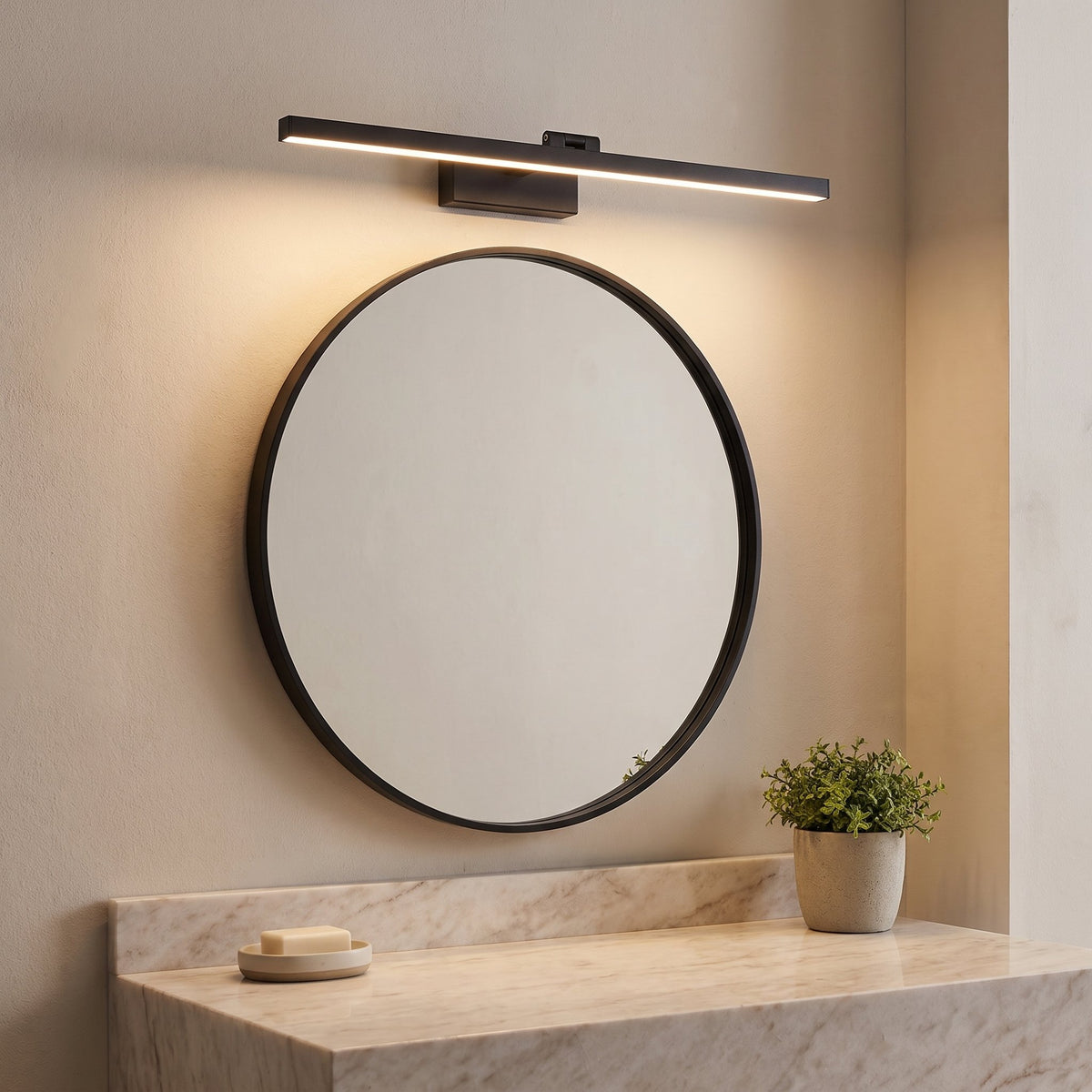 Pivot Vanity Light Bar lit warm above a round bathroom mirror