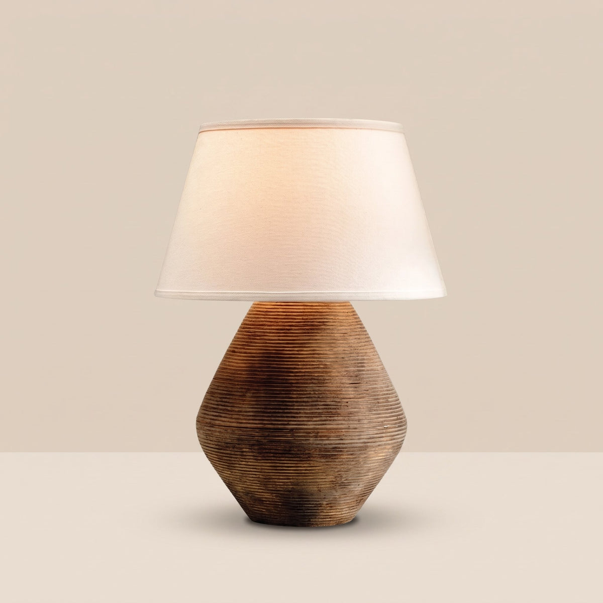 Reggio Ceramic Table Lamp — lit, sand backdrop