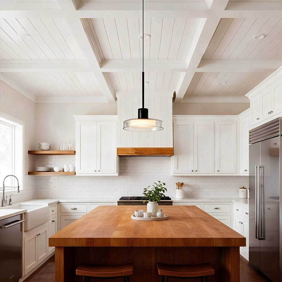 Puck Glass Pendant — clear glass above a wood kitchen island