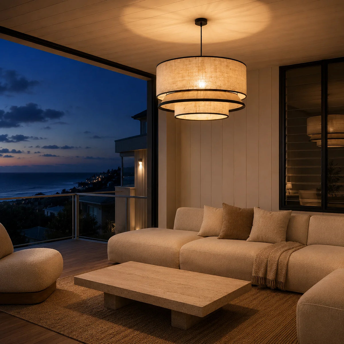 Sable tiered fabric pendant lit above a sofa and coffee table at dusk