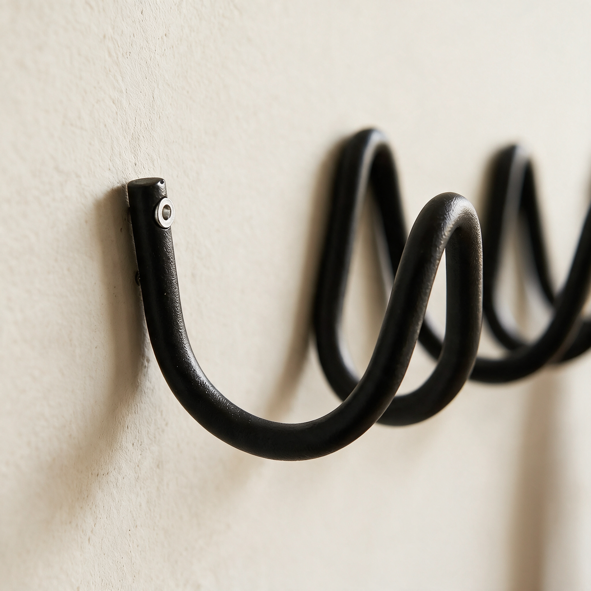 Close-up detail of the wave coat rack tube and wall mount