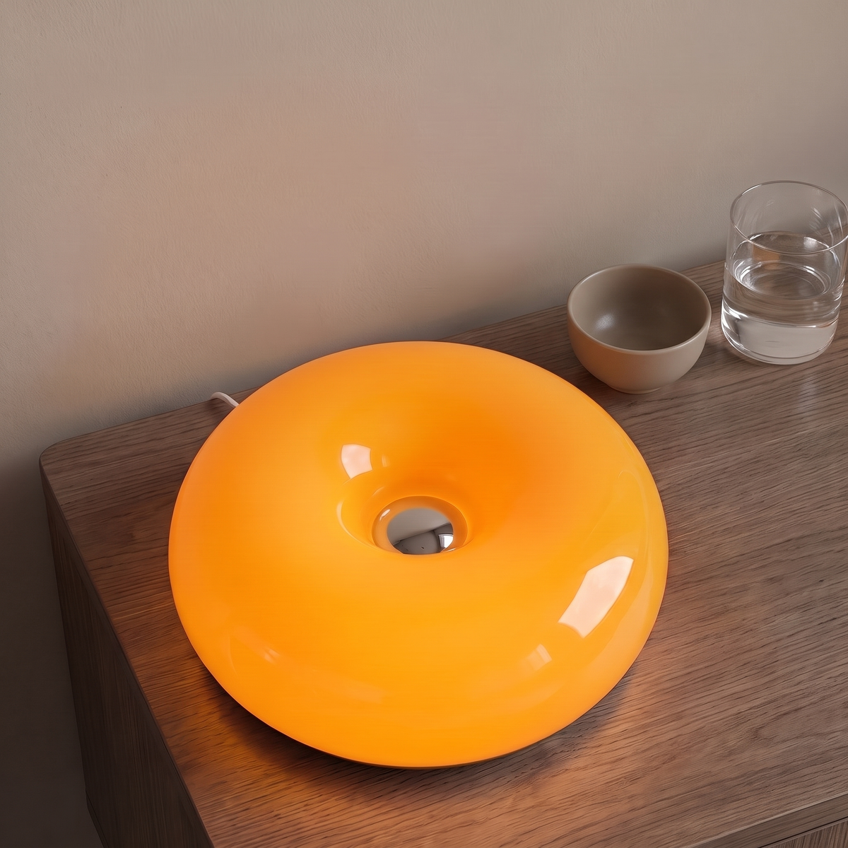 Halo Bauhaus Table Lamp in orange on a walnut side table with a ceramic bowl and water glass