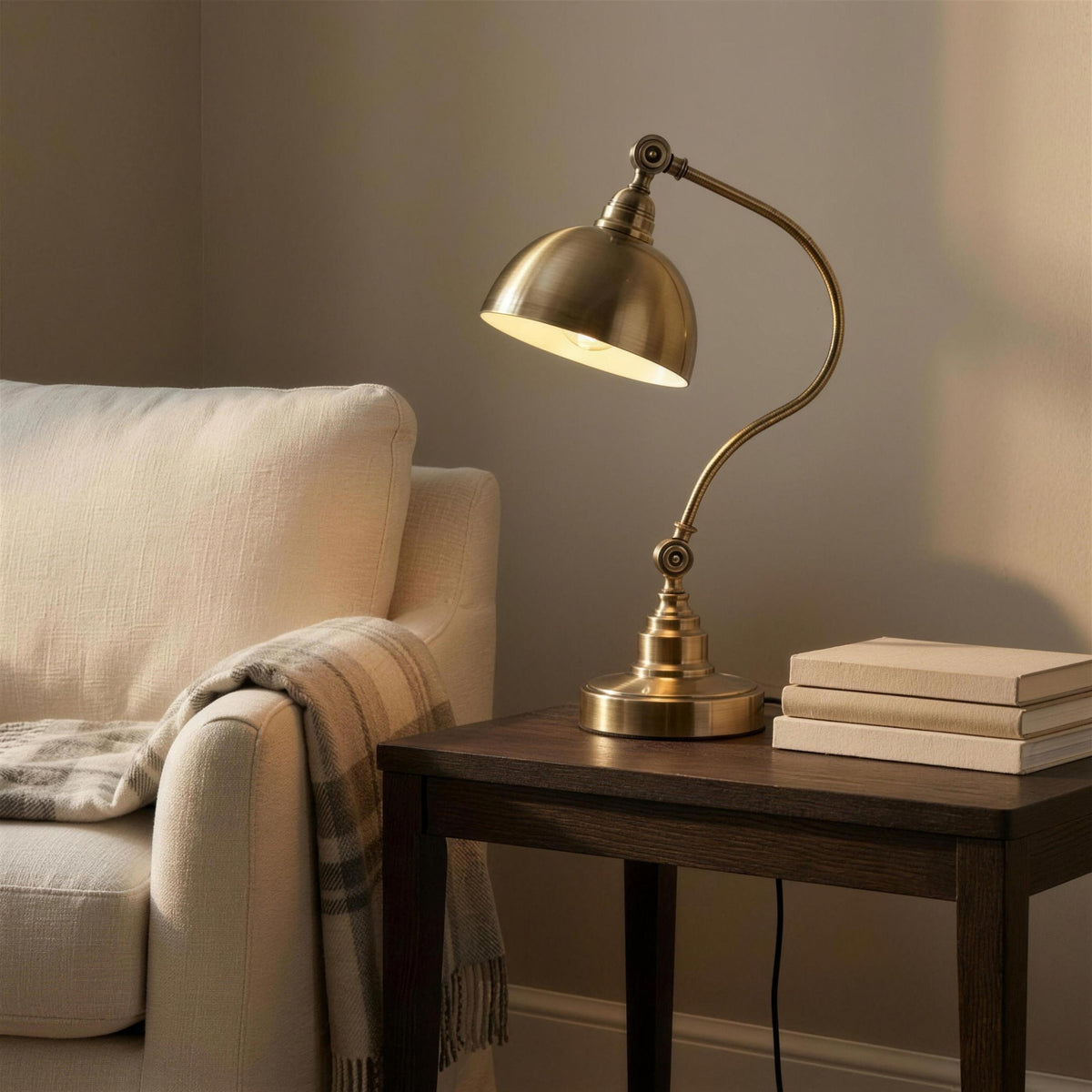 Antique Brass Gooseneck Desk Lamp - lit on a side table in a reading corner