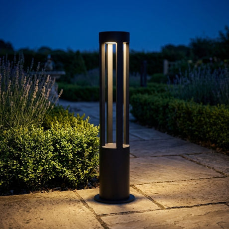 Tamsin Cylinder Bollard Light — lit on a garden path at night
