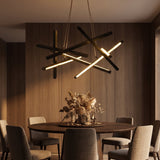 Tangent Bar Chandelier — lit above a dining table at dusk