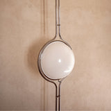 Chrome Globe Column Lamp — detail against a plaster wall