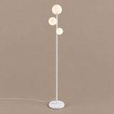 Trio Globe Floor Lamp — White, angled studio view