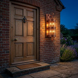 Corbel Wall Lantern — copper six-bulb lantern beside a cottage door at night