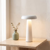 Porcini Table Lamp — White, lit, on travertine