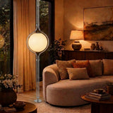 Chrome Globe Column Lamp — dusk living room with garden view
