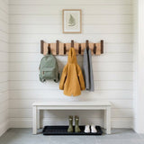 Orlo Piano Key Coat Rack — in a mudroom above a white bench with a backpack and rain jacket