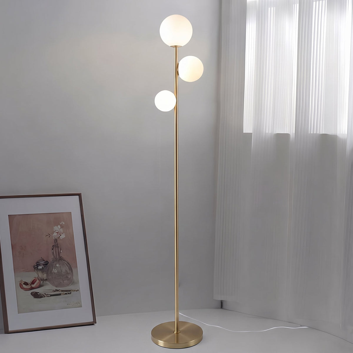 Trio Globe Floor Lamp — Gold with still-life art