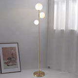 Trio Globe Floor Lamp — Gold with still-life art