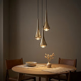 Teardrop Mini Pendant — Gold pendants over a round dining table at dusk
