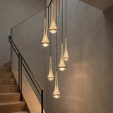 Teardrop Mini Pendant — Gold pendant cluster in a stairwell at dusk