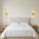 Duo Twin Rod Wall Sconce — mirrored pair beside a bed