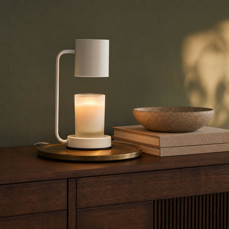Ember candle warmer lamp in white on a walnut sideboard against a sage wall