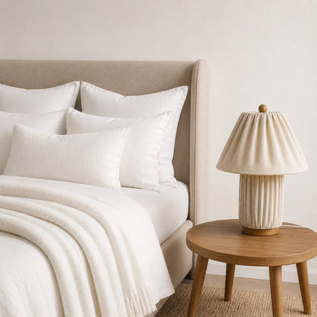 Plisse Fabric Table Lamp — Cream, on a bedside table