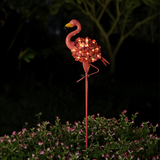 Blossom Flamingo Stake Light - lifestyle image garden border at night