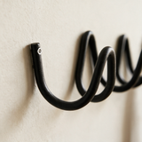 Close-up detail of the wave coat rack tube and wall mount