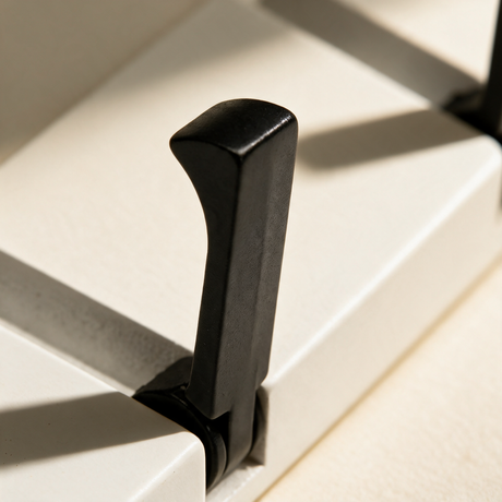 Close-up of a fold-down black hook on the white coat rack