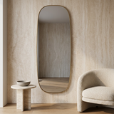 Modern Oval Full Length Wall Mirror, Slim Brass Frame — against a travertine wall