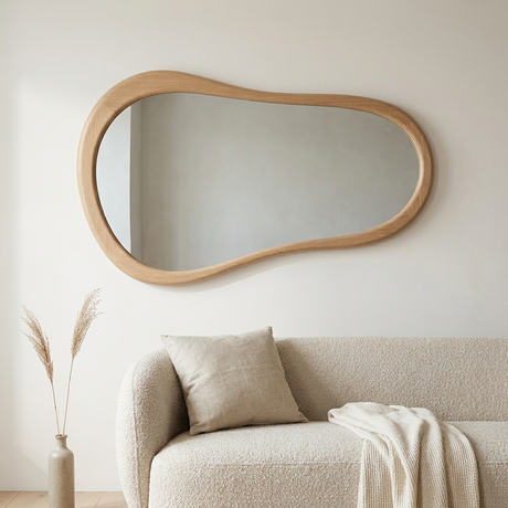 Cloud Shape Wall Mirror, Oak Finish — on a chalk-white wall above a bouclé sofa
