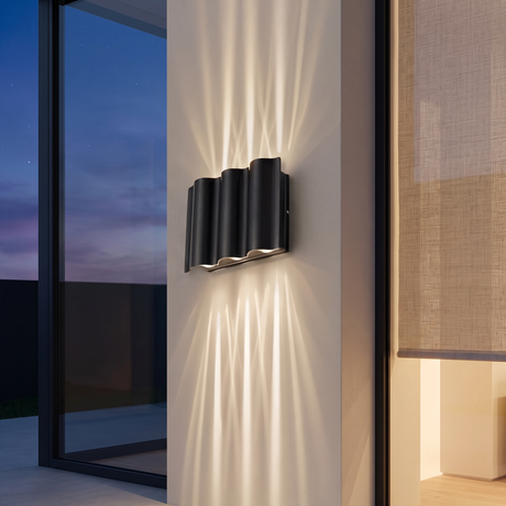6-light wave wall sconce projecting crossing light beams up and down a limewashed exterior pillar at dusk