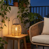 Woven Solar Lantern — Dense Rattan on a balcony side table