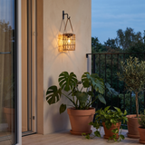 Woven Solar Lantern — X-Shaped hanging on a balcony wall