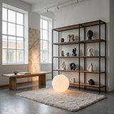 Luna Sphere Floor Lamp next to an open shelf of sculptural objects