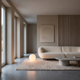 Luna Sphere Floor Lamp 30 cm beside a curved cream sofa in a minimalist living room