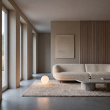 Luna Sphere Floor Lamp 25 cm beside a curved cream sofa in a minimalist living room