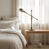 Brass Boom-Arm Desk Lamp - on a bedside table at dusk