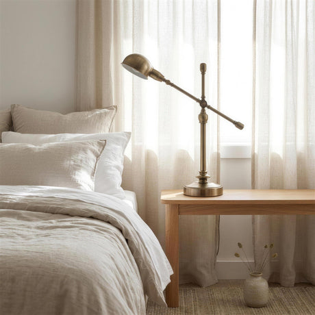 Brass Boom-Arm Desk Lamp - on a bedside table at dusk