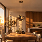 Twist Ribbon Pendant Light — over a dining table at golden hour, lamp on
